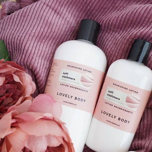 Two bottles of lotion lying on pink corduroy with flowers.