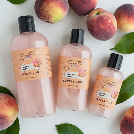 Three bottles of Peachy Keen Lovely Body bubble bath with peaches and leaves on a light background