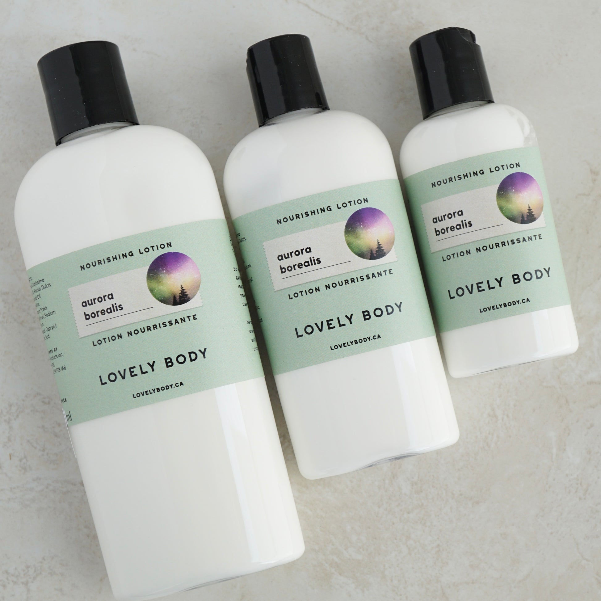 Three bottles of lotion, in graduated sizes of 8 oz, 4 oz, and 2 oz. Labels all same, pale green, say aurora borealis.