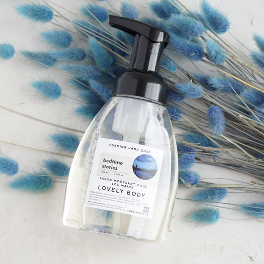 Bottle of foaming soap on blue grass background