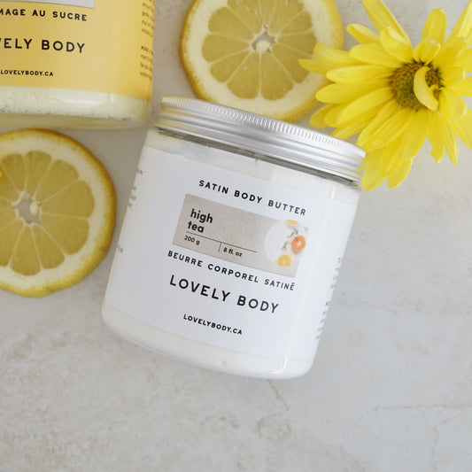 Jar of body butter posed with lemon slices and yellow flowers